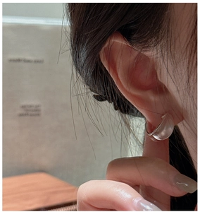 Close-up of minimalist matte C-shaped hoop earrings worn for a sleek modern aesthetic