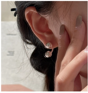 Macro view of S925 sterling silver ball earrings featuring a minimalist double-sphere design