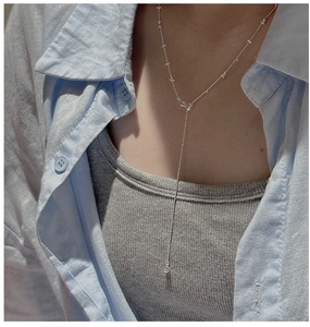 Macro shot of S925 sterling silver Y-shaped bead necklace on collarbone with ziron pendant