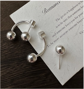 Macro view of polished S925 sterling silver ball earrings with curved bar detail
