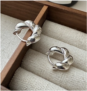 Detail of S925 sterling silver twisted rope hoop earrings on jewelry box liner