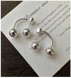 Macro shot of S925 sterling silver ball earrings featuring U-shaped minimalist design