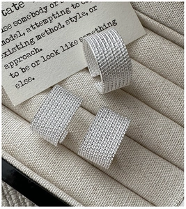 Detailed close-up of S925 sterling silver rings with braided texture on a velvet stand
