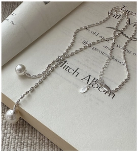 Detailed view of S925 sterling silver necklace with pearl tassels and engraved tag