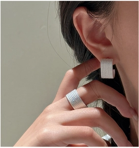 Detailed close-up of S925 sterling silver earrings with textured woven grid pattern