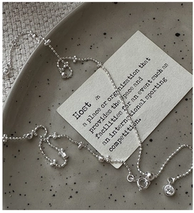 Macro view of S925 sterling silver chain with a round zircon pendant on ceramic dish