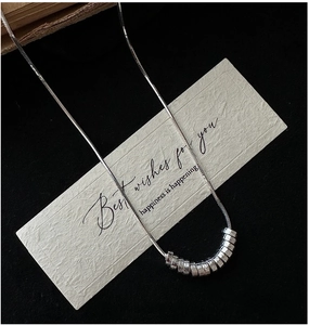 Macro detail of S925 silver snake chain necklace featuring hammered circular beads