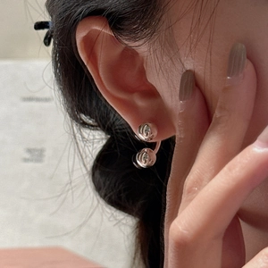 Minimalist S925 sterling silver U-shaped double bead earrings worn on an earlobe