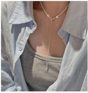 Detail of S925 sterling silver Y-shaped tassel necklace on a model with striped shirt