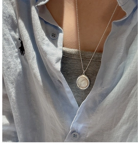 Nahaufnahme einer minimalistischen S925 Silberhalskette mit Perlmuttanhänger für Damen