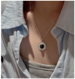 Detail of S925 silver necklace with textured obsidian pendant on satellite chain