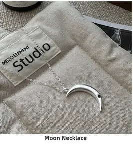 Detail of 925 sterling silver moon pendant with black zircon on quilted fabric