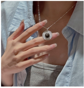 Close-up of S925 sterling silver necklace with textured obsidian pendant on model