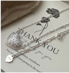 Detailed macro shot of 925 sterling silver heart pendant with unique caviar texture
