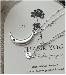 Macro detail of 925 silver crescent necklace with matte texture and black zircon stone