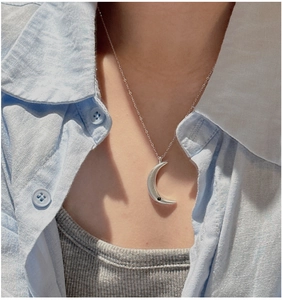 Close-up of 925 silver crescent moon necklace with black zircon on model's neckline