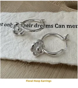 Détail macro de boucles d'oreilles fleurs en argent S925 avec texture en relief vintage