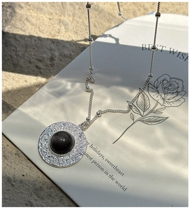 Close-up of vintage S925 silver necklace with textured obsidian pendant on card