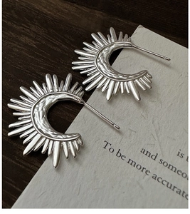 Macro shot of S925 sterling silver fan earrings with hammered vintage texture and studs
