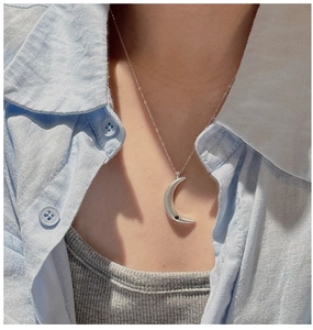 Close-up of 925 silver crescent moon pendant with black zircon on model's neck