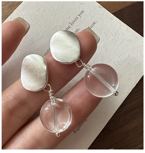 Macro shot of matte S925 silver earrings with transparent round crystal bead drop