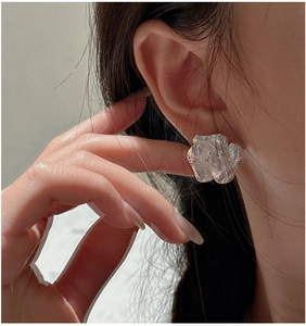 Close-up of S925 sterling silver floral earring with artistic brushed texture on ear