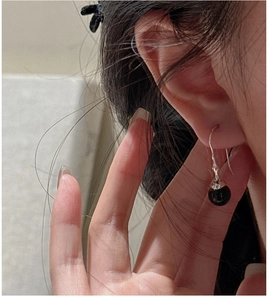 Nahaufnahme von Vintage-Ohrringen mit schwarzen Onyx-Kugeln und Silberhaken