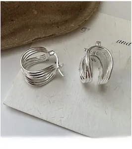 Detailed close-up of S925 sterling silver U-shape earrings with irregular wrap design