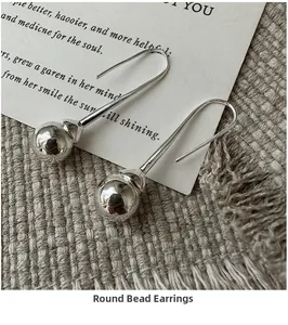 Gros plan de boucles d'oreilles boules argentées avec perles polies et crochets fins