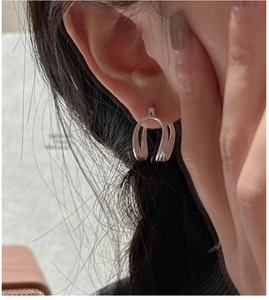 Close-up of minimalist S925 sterling silver U-shaped earrings worn by a model
