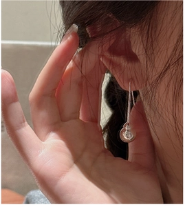 Vue rapprochée des boucles d'oreilles goutte en argent S925 poli portées par un mannequin