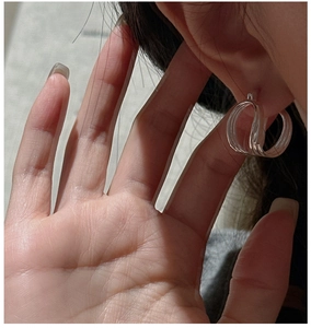 Macro shot of minimalist multi-layer clear resin C-shaped clip-on earrings for women