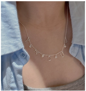 Close-up of S925 silver LUCKY letter necklace with sparkling zircons on a model