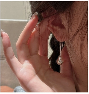 Gros plan de boucles d'oreilles pendantes en argent sterling S925 portées par le mannequin