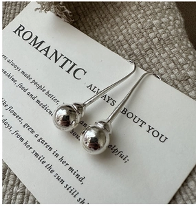 Détail montrant le poinçon S925 sur les boucles d'oreilles boules minimalistes