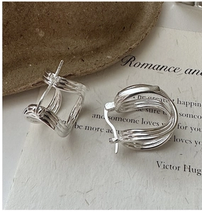 Detail of S925 sterling silver U-shaped hoop earrings with a twisted metal design