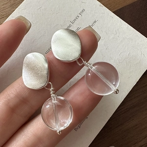 S925 sterling silver matte earrings with transparent sphere pendants held in hand