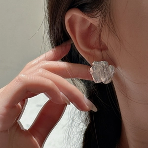 S925 sterling silver flower earrings with brushed metal texture worn by a model