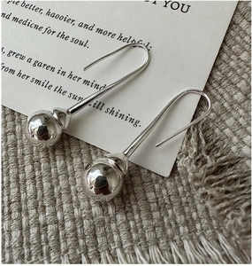 Vue macro de boucles d'oreilles minimalistes en argent S925 avec billes polies