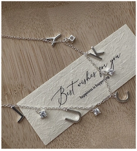 Macro detail of S925 silver LUCKY pendant necklace with sparkling zircon stones