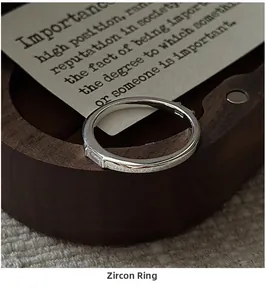 Macro view of S925 sterling silver ring with rectangular zircon in wooden box