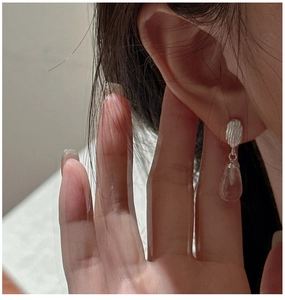 Gros plan de boucles d'oreilles en argent 925 avec cristal clair et détails striés