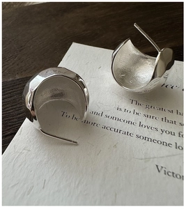 Macro view of textured S925 silver hoop earrings with hammered finish and matte interior