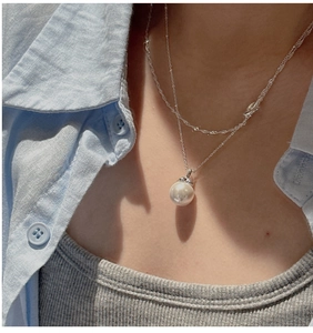 Double-layer silver necklace featuring a white shell pearl pendant on a minimal link chain