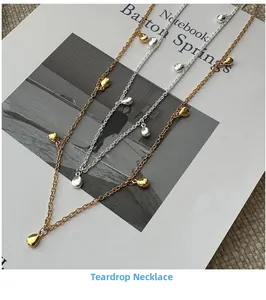Détail de colliers avec pendentifs goutte d'eau dorés et argentés sur fond soigné