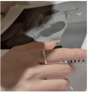 Detail of minimalist S925 sterling silver ring with double-sided zircon on finger