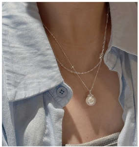 Close-up of a large white shell pearl pendant on a minimalist S925 silver chain necklace
