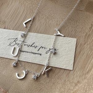 S925 silver lucky necklace with zircon accents on a rustic wooden background