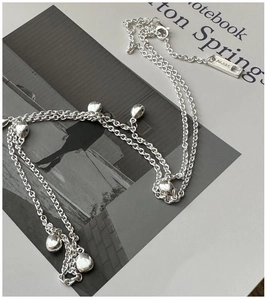 Détail d'un collier en argent massif avec breloques cœurs 3D polies et poinçon Ag925