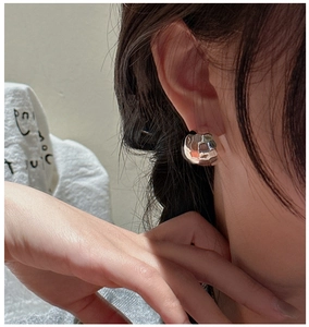 Close-up of S925 silver rhombus earrings with hammered texture worn on a female model